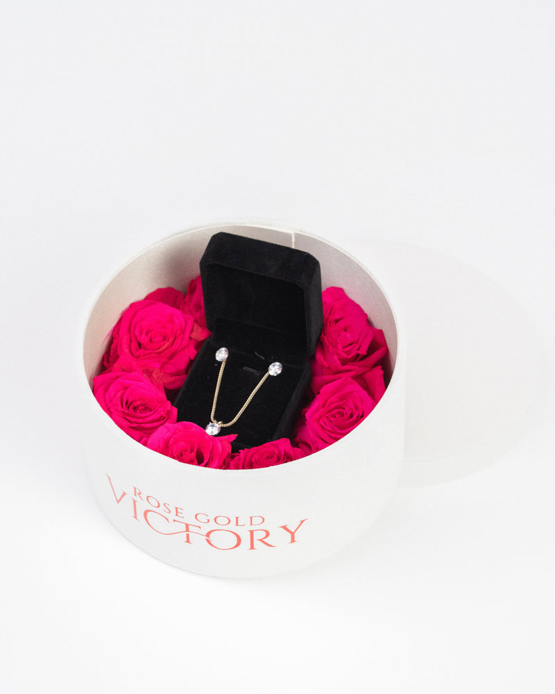 Hot pink preserved roses with a gold jewelry set in a white round box — Rose Gold Victory