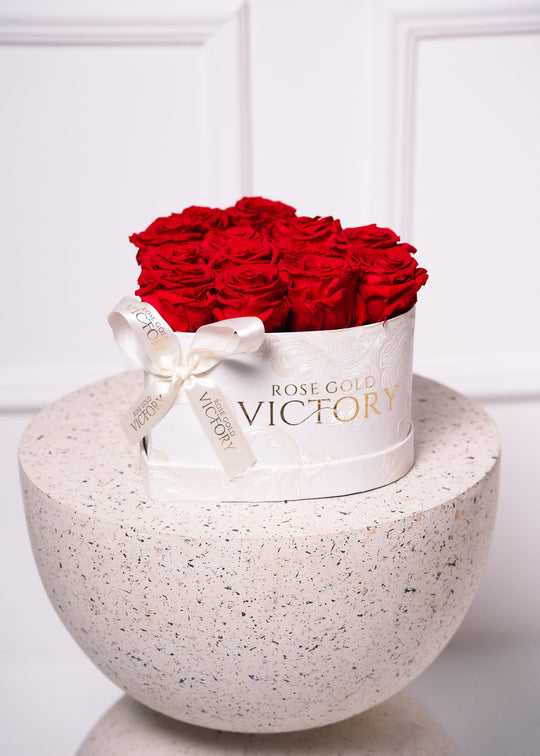 Red preserved-rose dome in a white Rose Gold Victory velvet box on a terrazzo pedestal