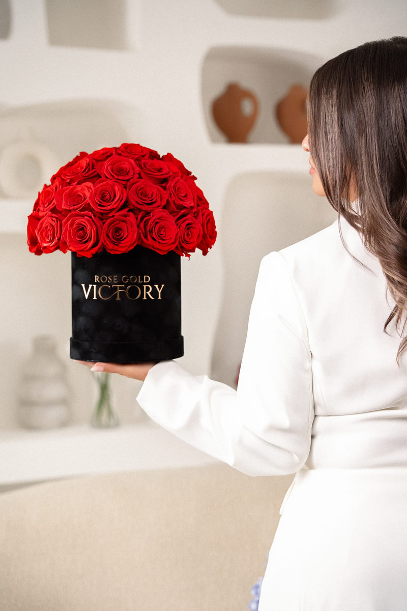 Model presenting a Rose Gold Victory red-rose dome box in a bright modern interior